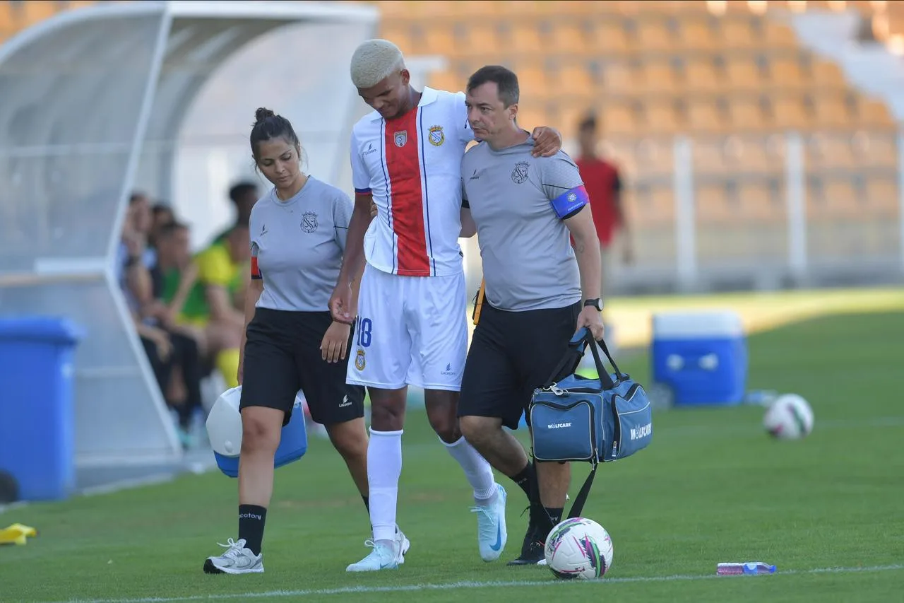 Dr. Rodrigo Oliveira amparando atleta na saída do campo