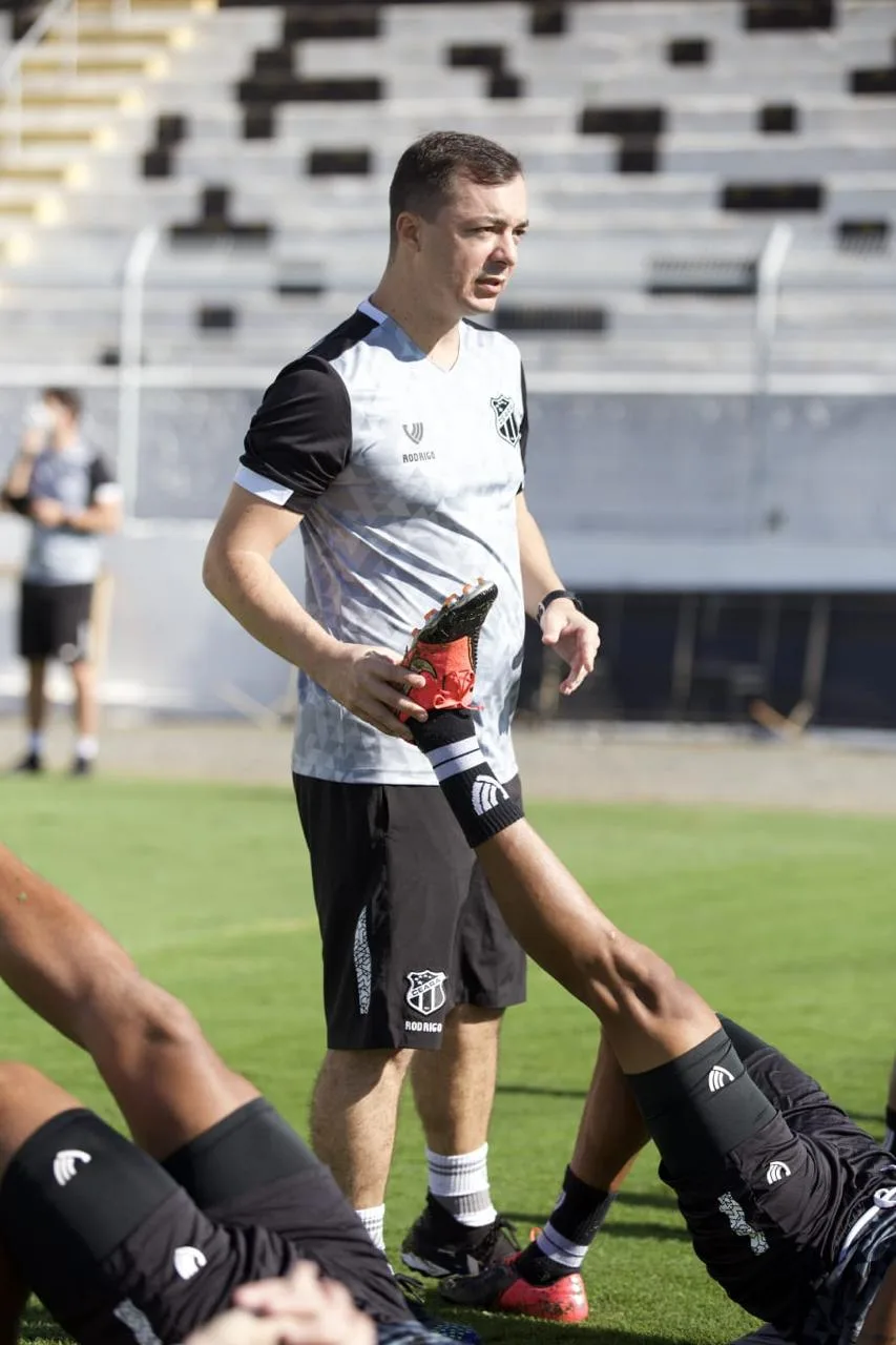 Dr. Rodrigo Oliveira conduzindo alongamento de atleta em estádio